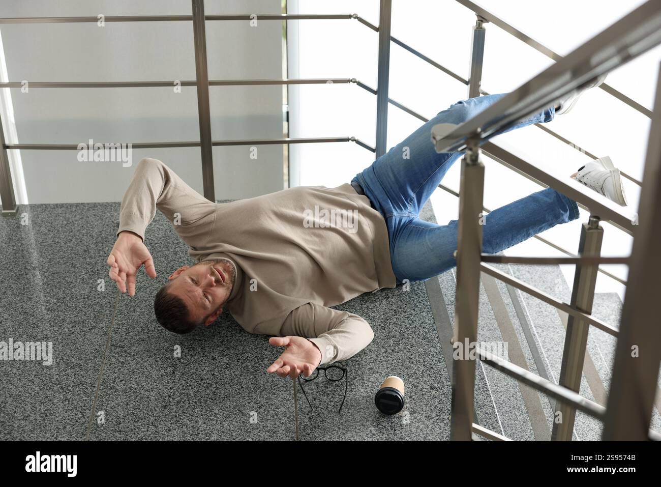 Injured man on stairs in building after fall. Dangerous accident Stock ...