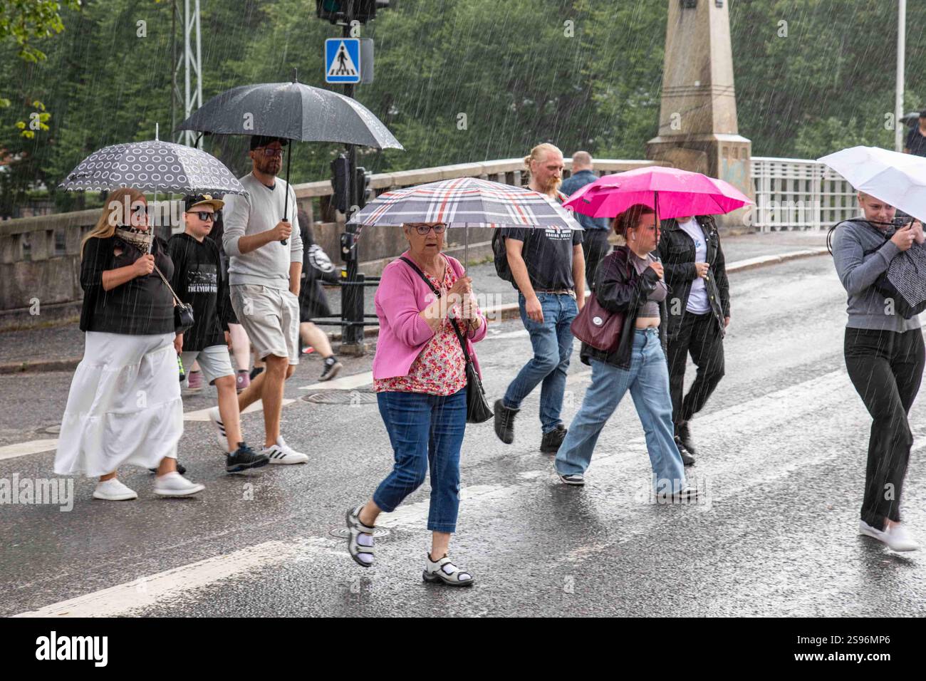 People with umbrellas crossing Aurakatu in a summer rain in Turku, Finland Stock Photo