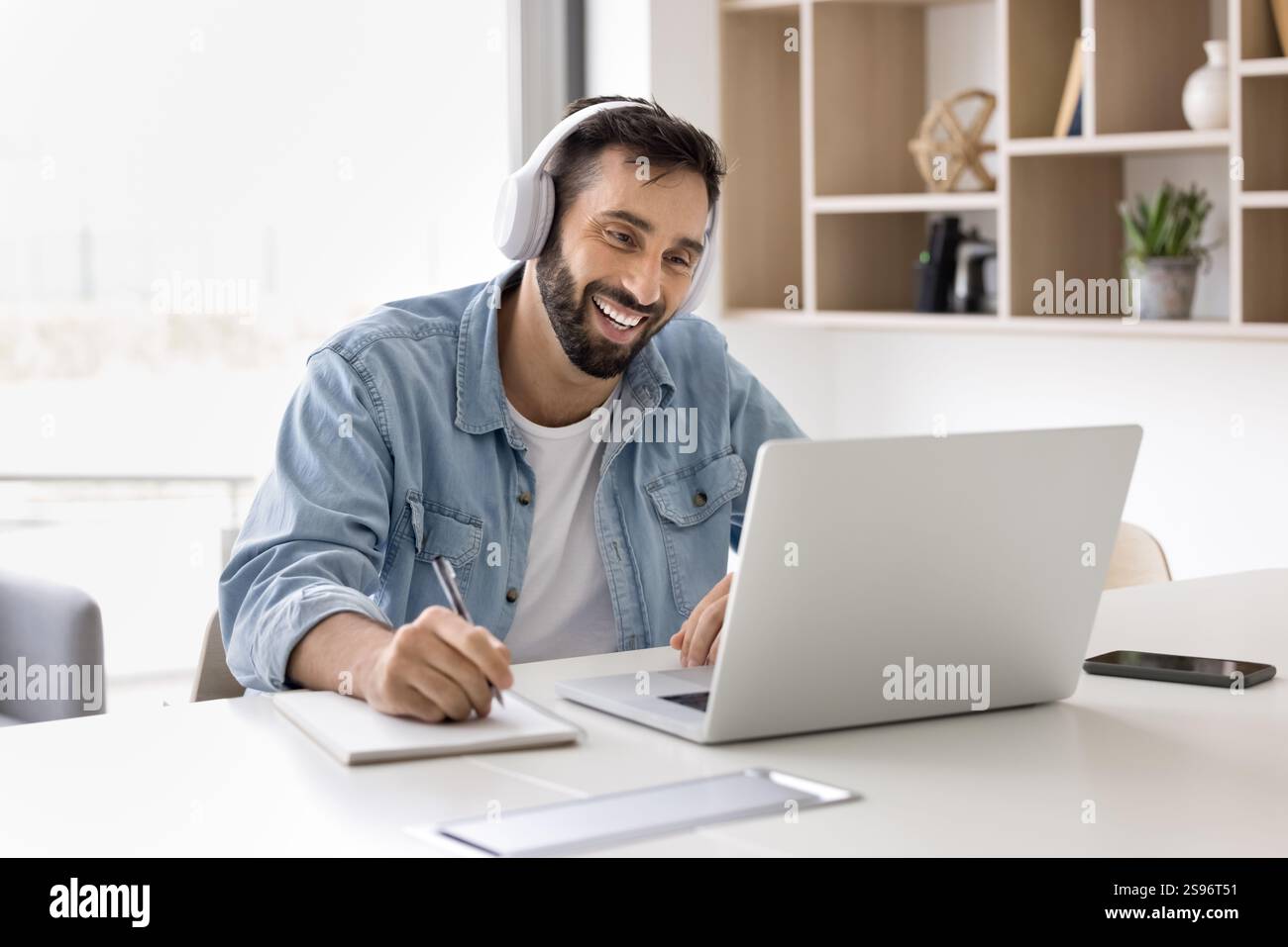 Man take part in online class using laptop and application Stock Photo