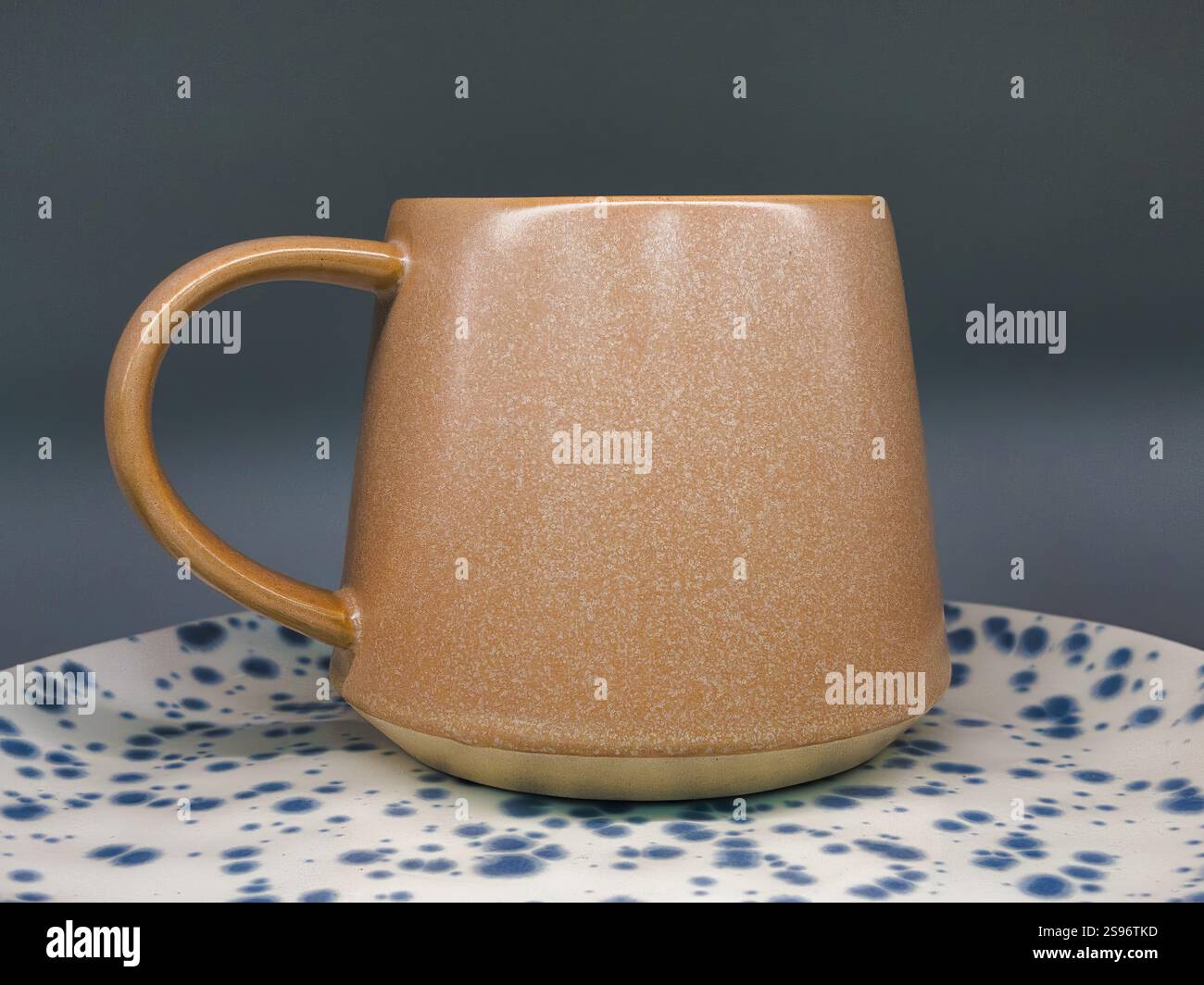 Artisanal ceramic mug on decorative spotted plate - Smartphone Captured Stock Image