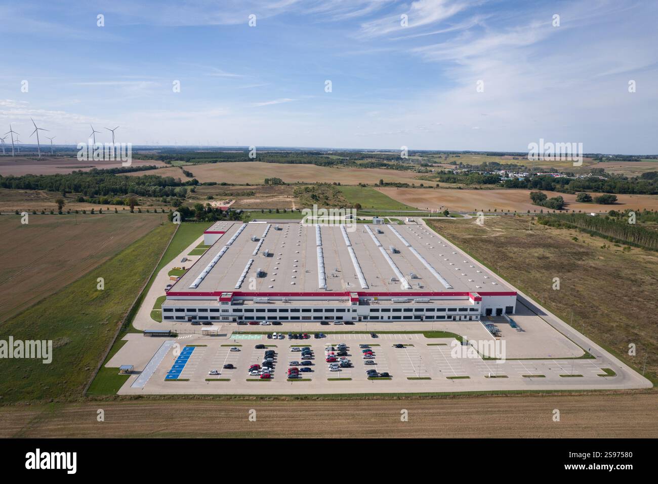 Aerial View of a Large Distribution Center with Parking Lot and Windmills Stock Photo