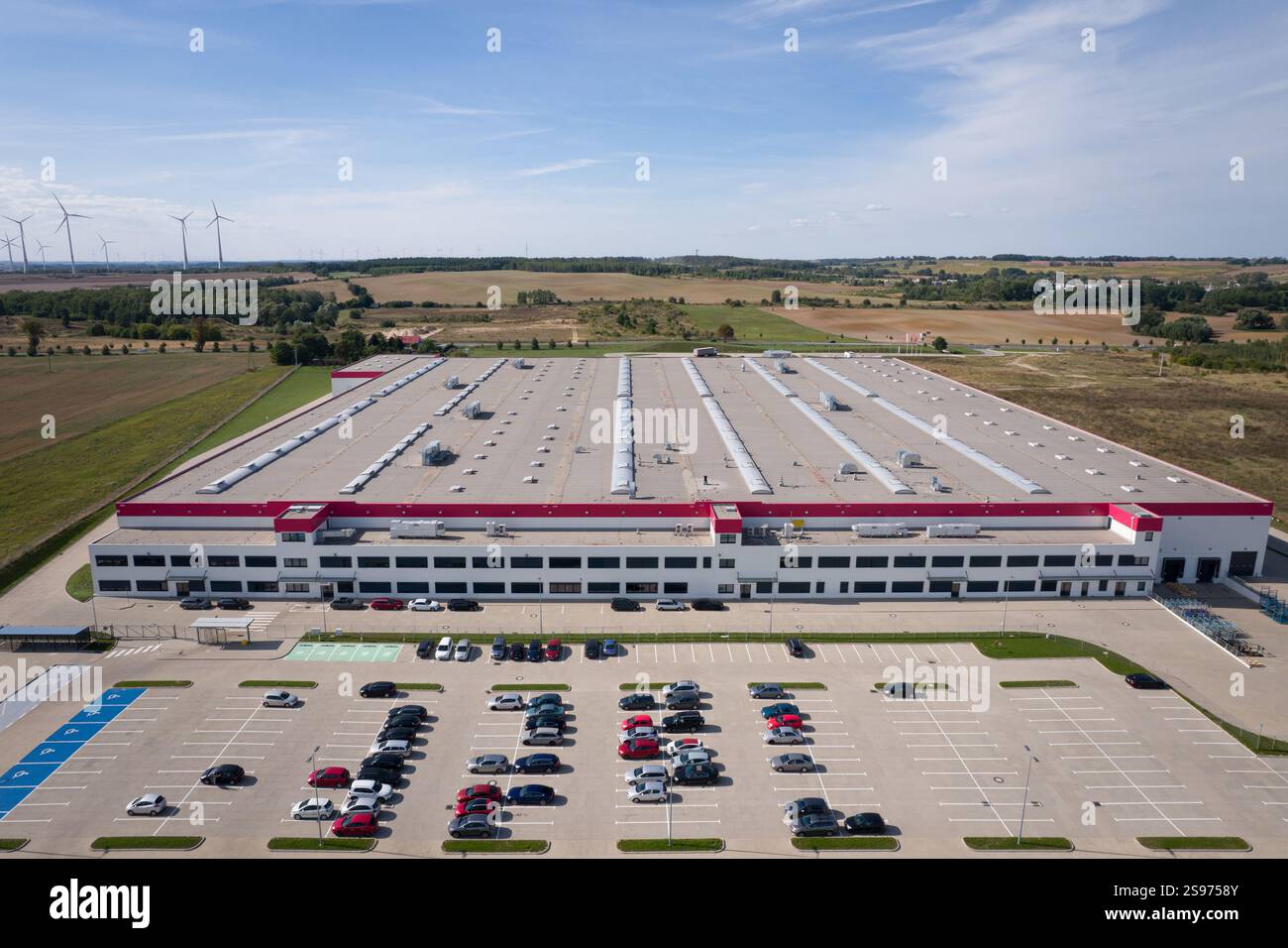 Aerial View of a Large Distribution Center with Parking Lot and Windmills Stock Photo