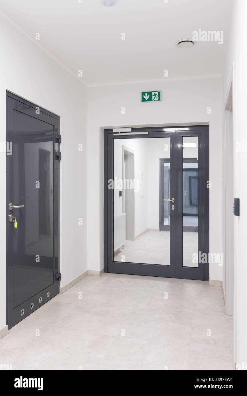 Modern Hallway with Emergency Exit Door and Access Control Stock Photo