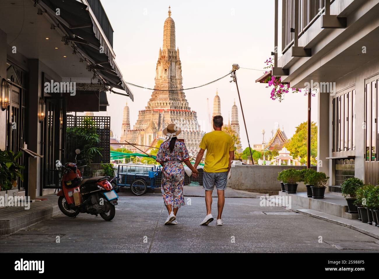 In the heart of Bangkok, a couple walks hand in hand down a charming ...