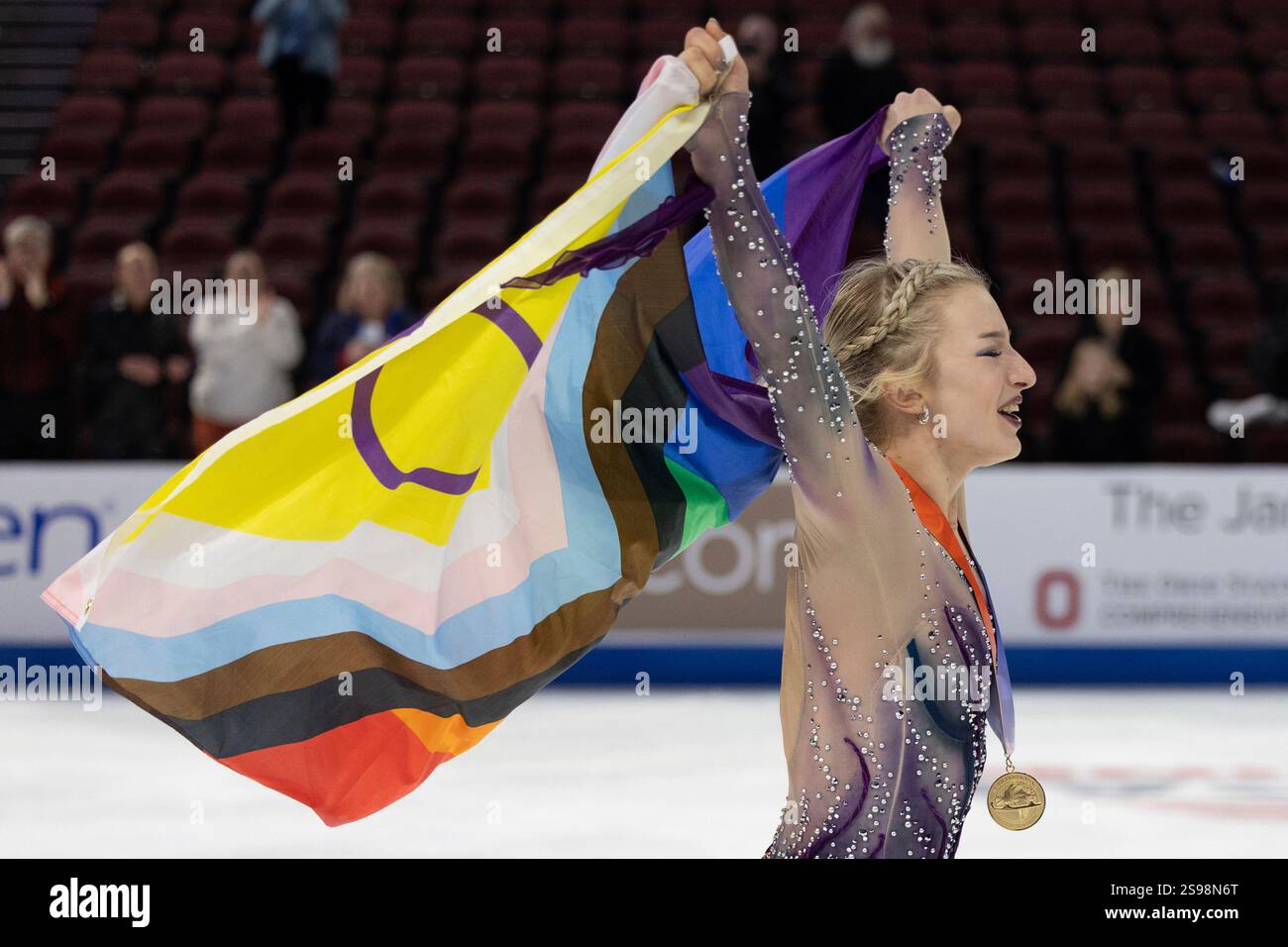Amber Glenn waves a pride flag and celebrates with fans after winning the women's competition at