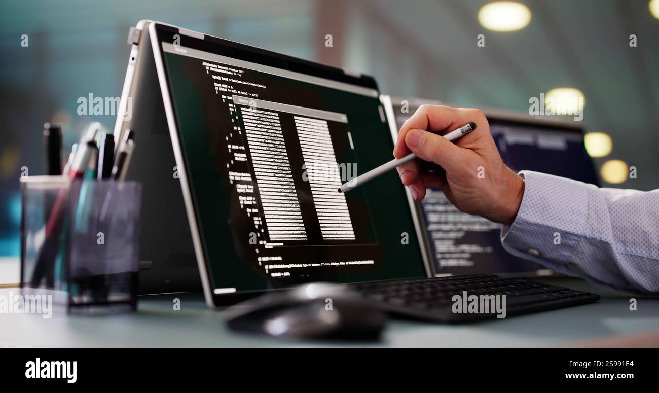 Programmer Or Coder At Office Desk Using Laptop Stock Photo