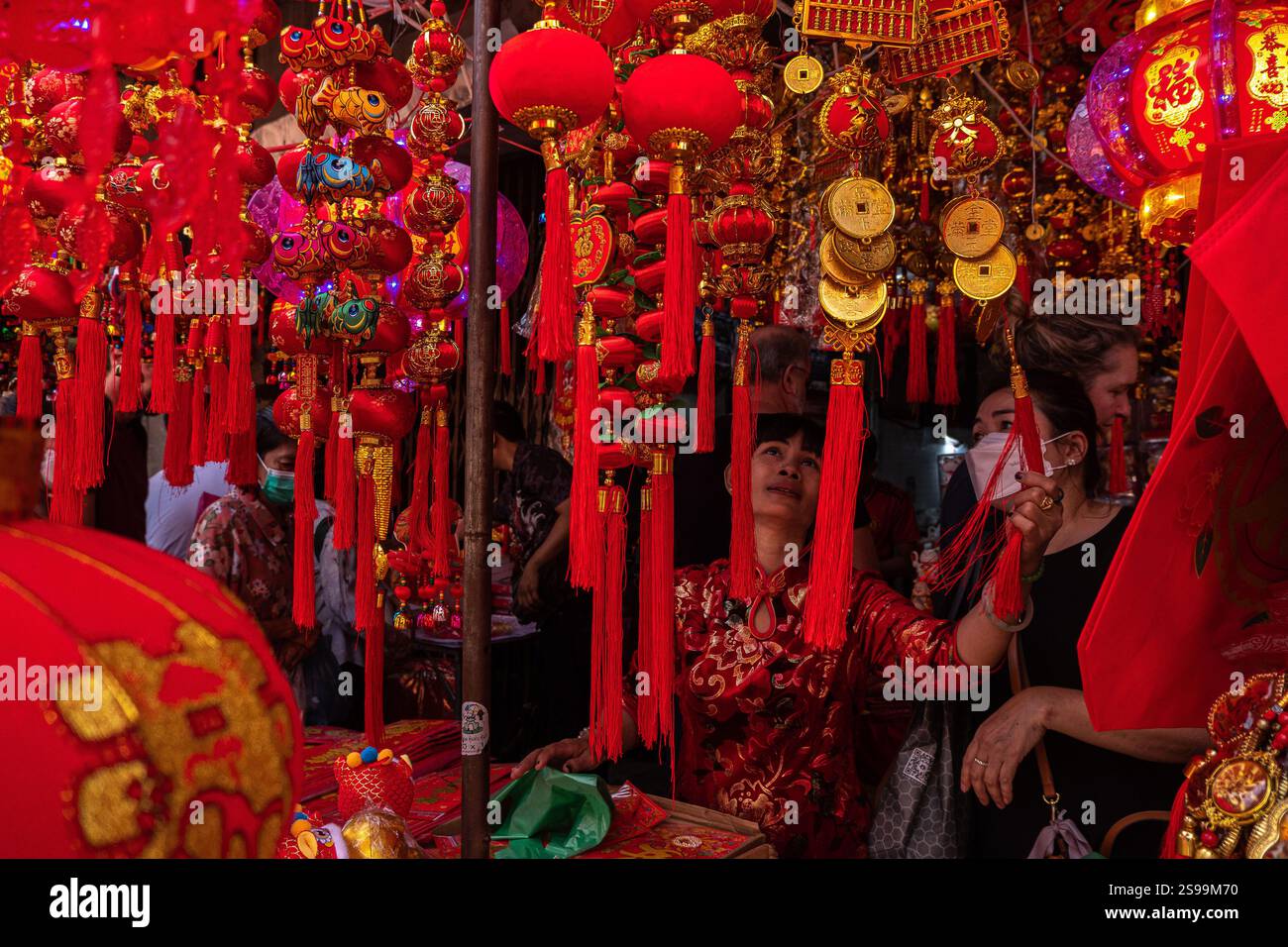 Women look through Chinese Lunar New Year festival decorations at a