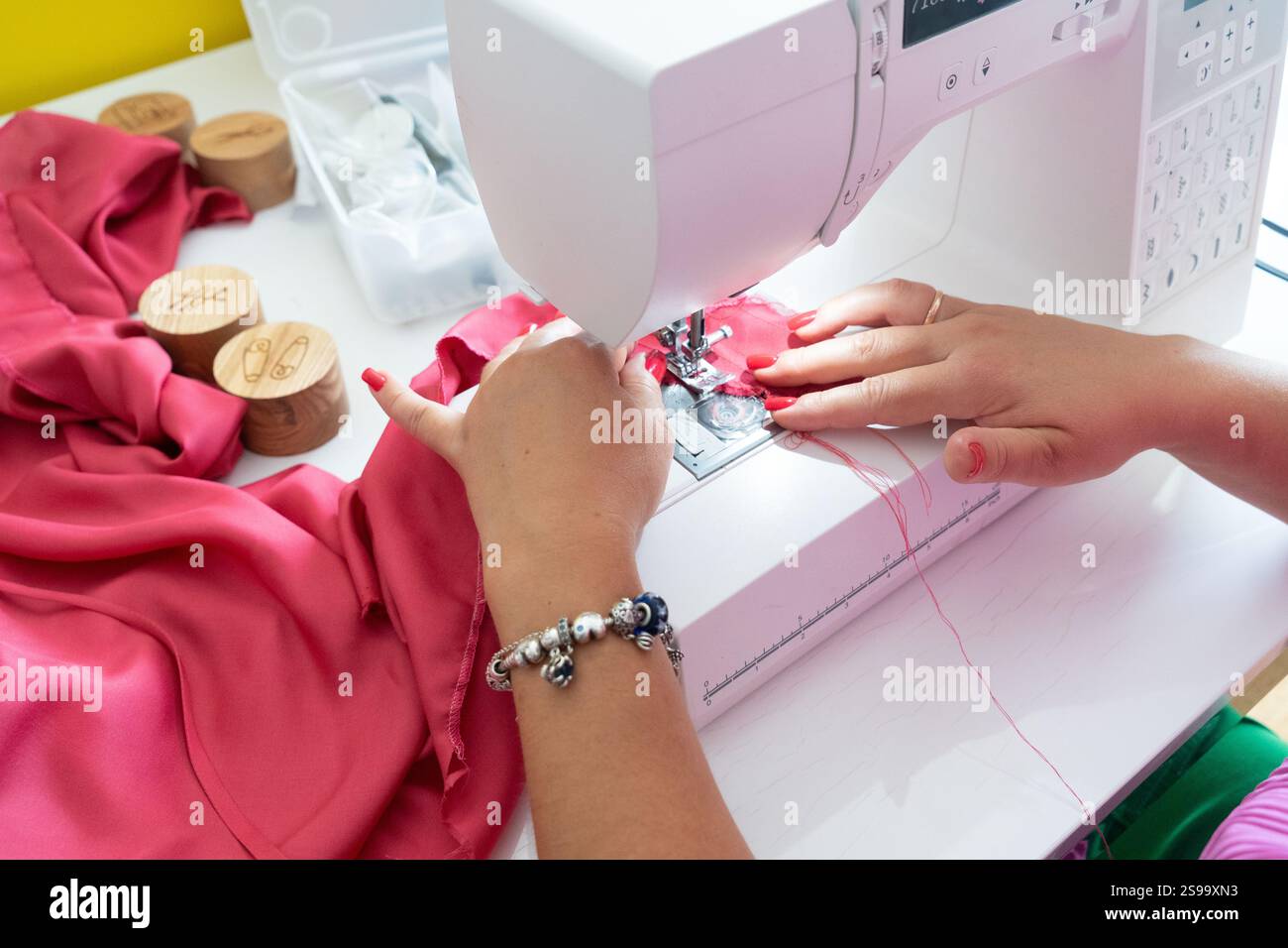 Sewing background with designers hands and sewing machine Stock Photo