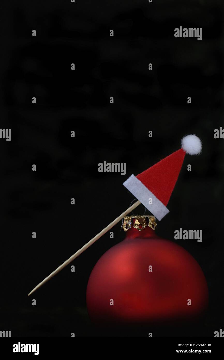 Red Christmas bauble and Christmas hat on a toothpick Stock Photo