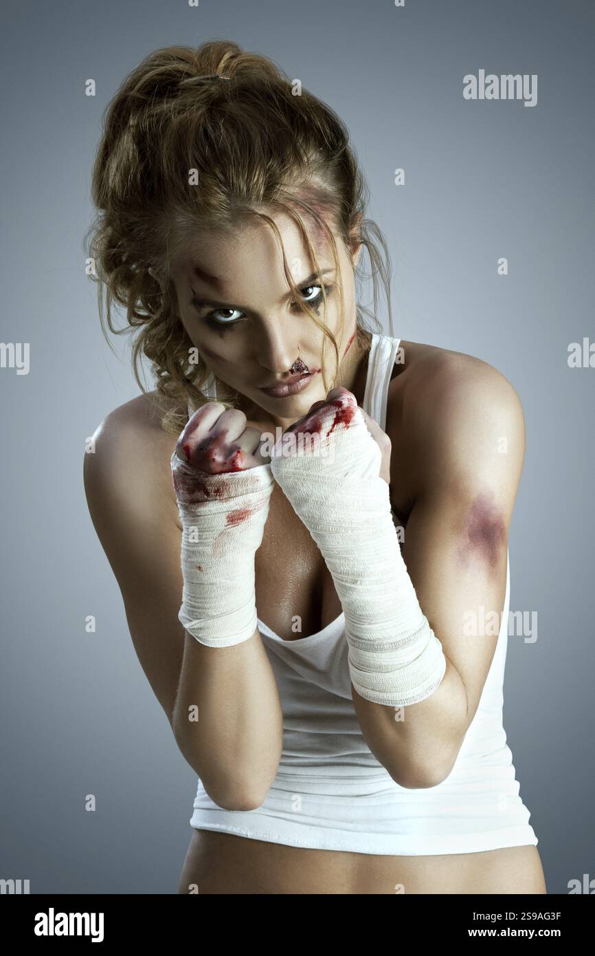 Neutral Fight Position Aggressive female fighter with bruises, wearing a bloody bandage around ...