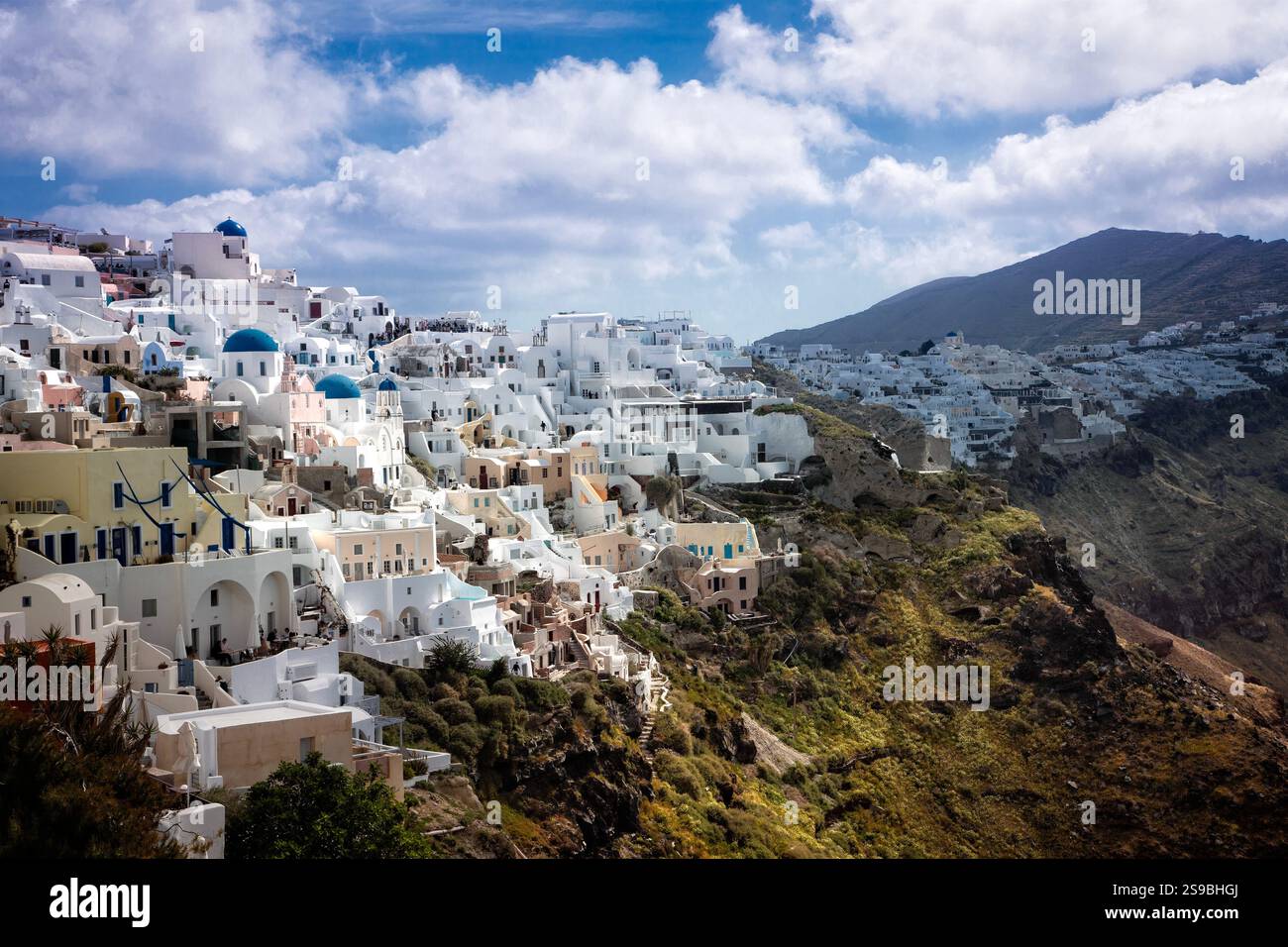 The picturesque village of Oia on Santorini, Greece, cascades gracefully down the caldera cliffs, offering breathtaking views of the Aegean Sea. Stock Photo