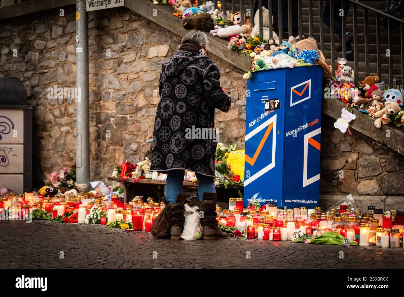 Aschaffenburg, Bavaria, Germany - January 25, 2025: In Schöntalpark in Aschaffenburg, people gather in silent mourning to commemorate the victims of the knife attack. Candles and flowers bear witness to sympathy, pain and solidarity in a deeply moved community *** Im Schöntalpark in Aschaffenburg versammeln sich Menschen in stiller Trauer, um der Opfer des Messerangriffs zu gedenken. Kerzen und Blumen zeugen von Anteilnahme, Schmerz und Solidarität in einer tief bewegten Gemeinschaft Stock Photo