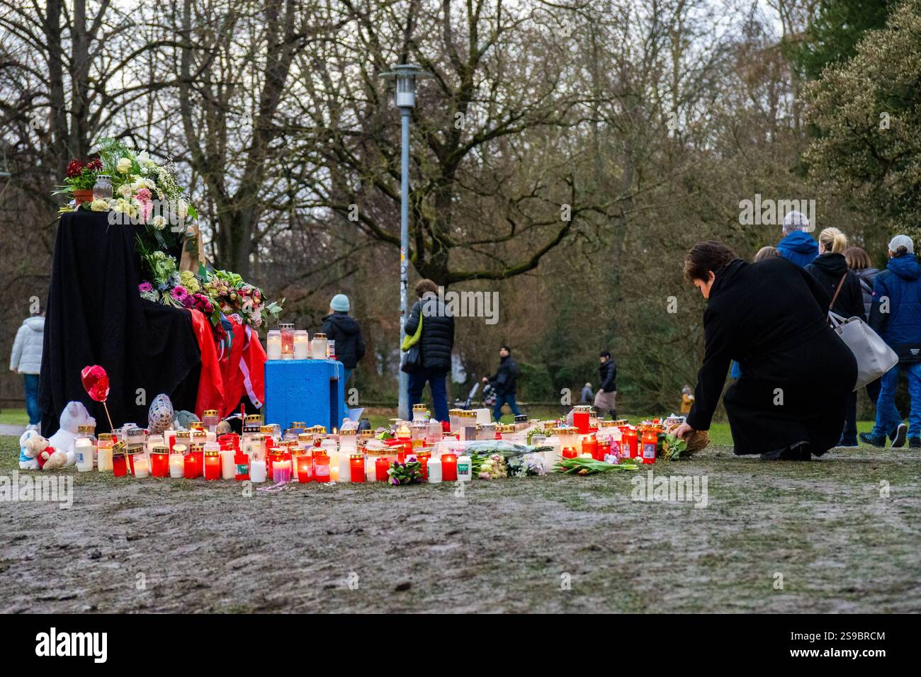 Aschaffenburg, Bavaria, Germany - January 25, 2025: In Schöntalpark in Aschaffenburg, people gather in silent mourning to commemorate the victims of the knife attack. Candles and flowers bear witness to sympathy, pain and solidarity in a deeply moved community *** Im Schöntalpark in Aschaffenburg versammeln sich Menschen in stiller Trauer, um der Opfer des Messerangriffs zu gedenken. Kerzen und Blumen zeugen von Anteilnahme, Schmerz und Solidarität in einer tief bewegten Gemeinschaft Stock Photo