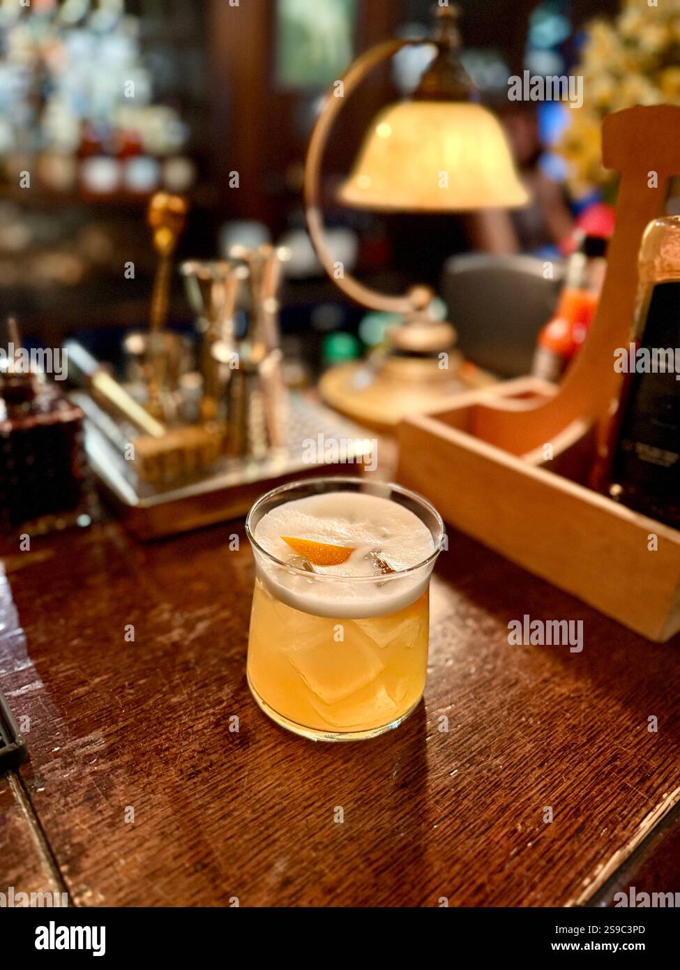 Whiskey sour cocktail served at pub bar with orange peel Stock Photo