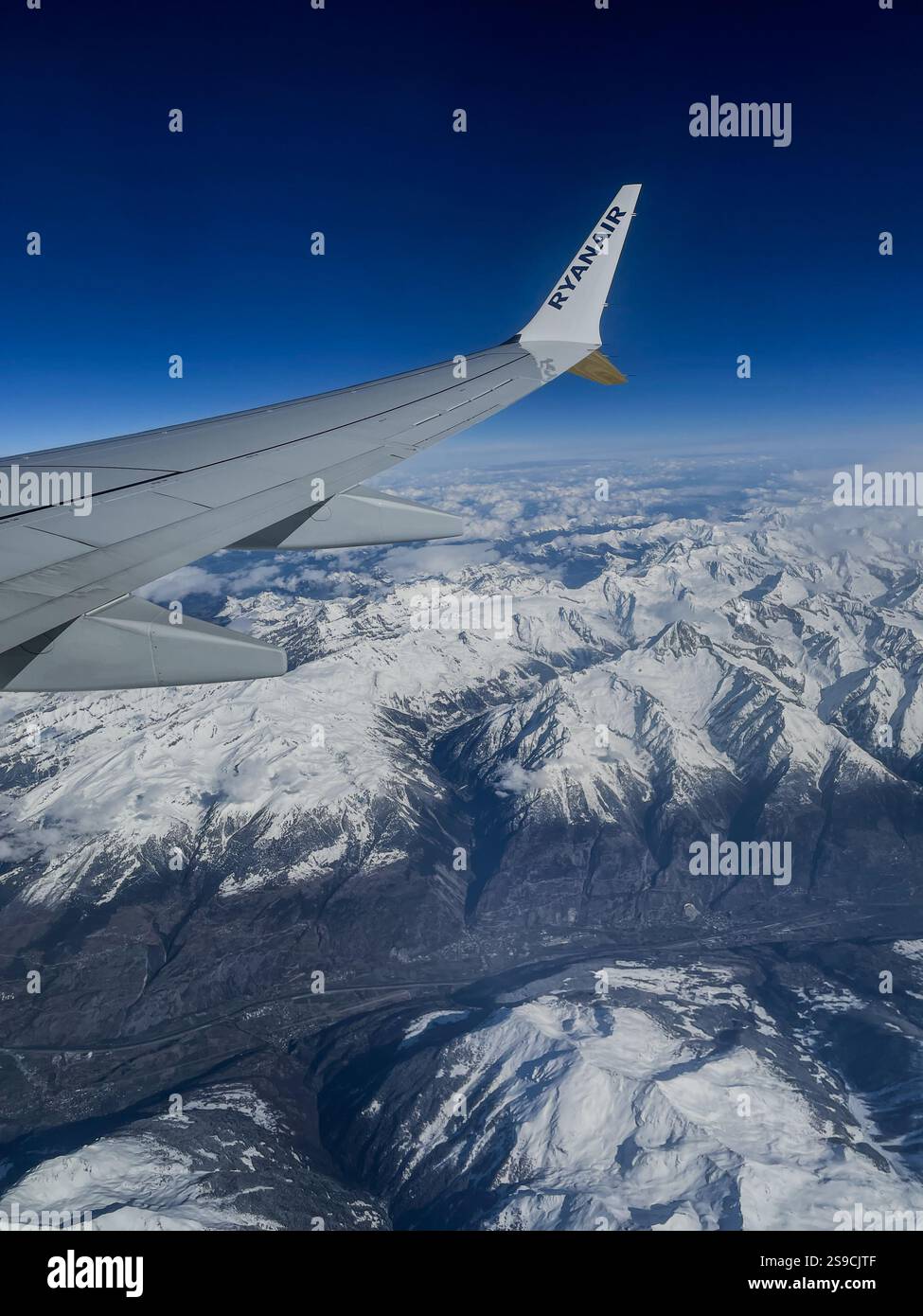View of a snowy European landscape from a Ryanair aircraft window - Smartphone Captured Stock Image