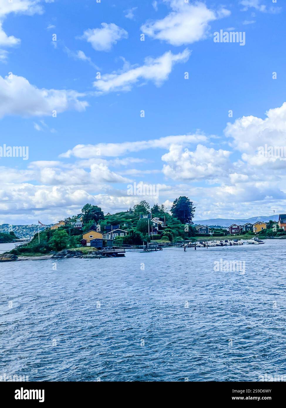 Traditional cottages on the tranquil islands of the Oslofjord, Norway, offering a peaceful summer retreat amidst scenic natural beauty - Smartphone Captured Stock Image