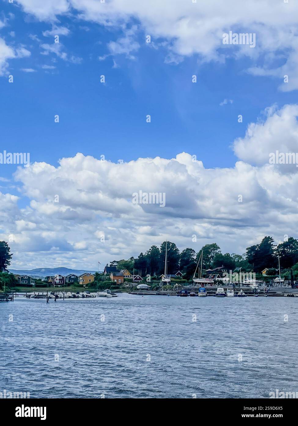 Traditional cottages on the tranquil islands of the Oslofjord, Norway, offering a peaceful summer retreat amidst scenic natural beauty. - Smartphone Captured Stock Image