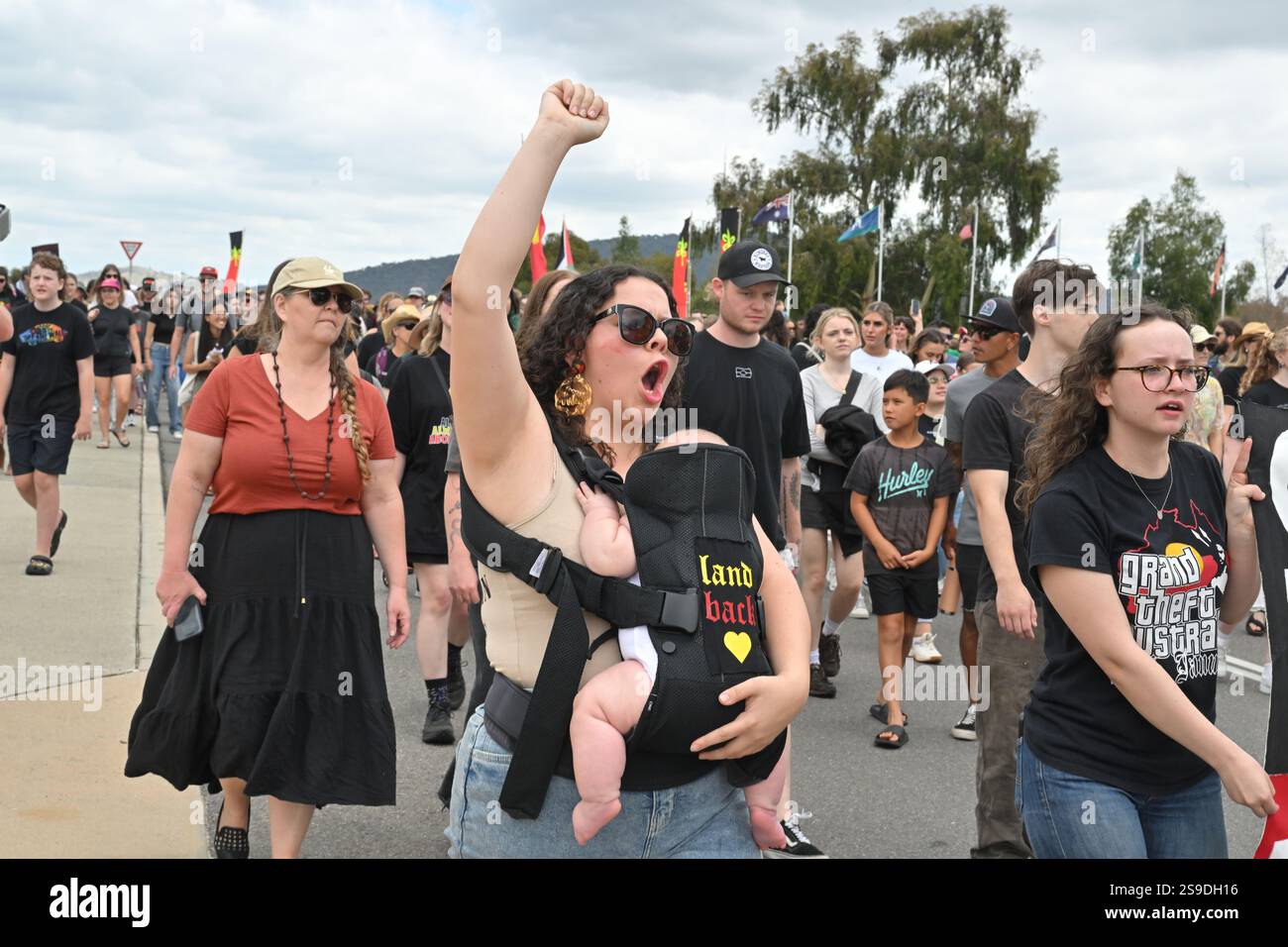 Protesters march past Parliament House during an Invasion Day rally in ...