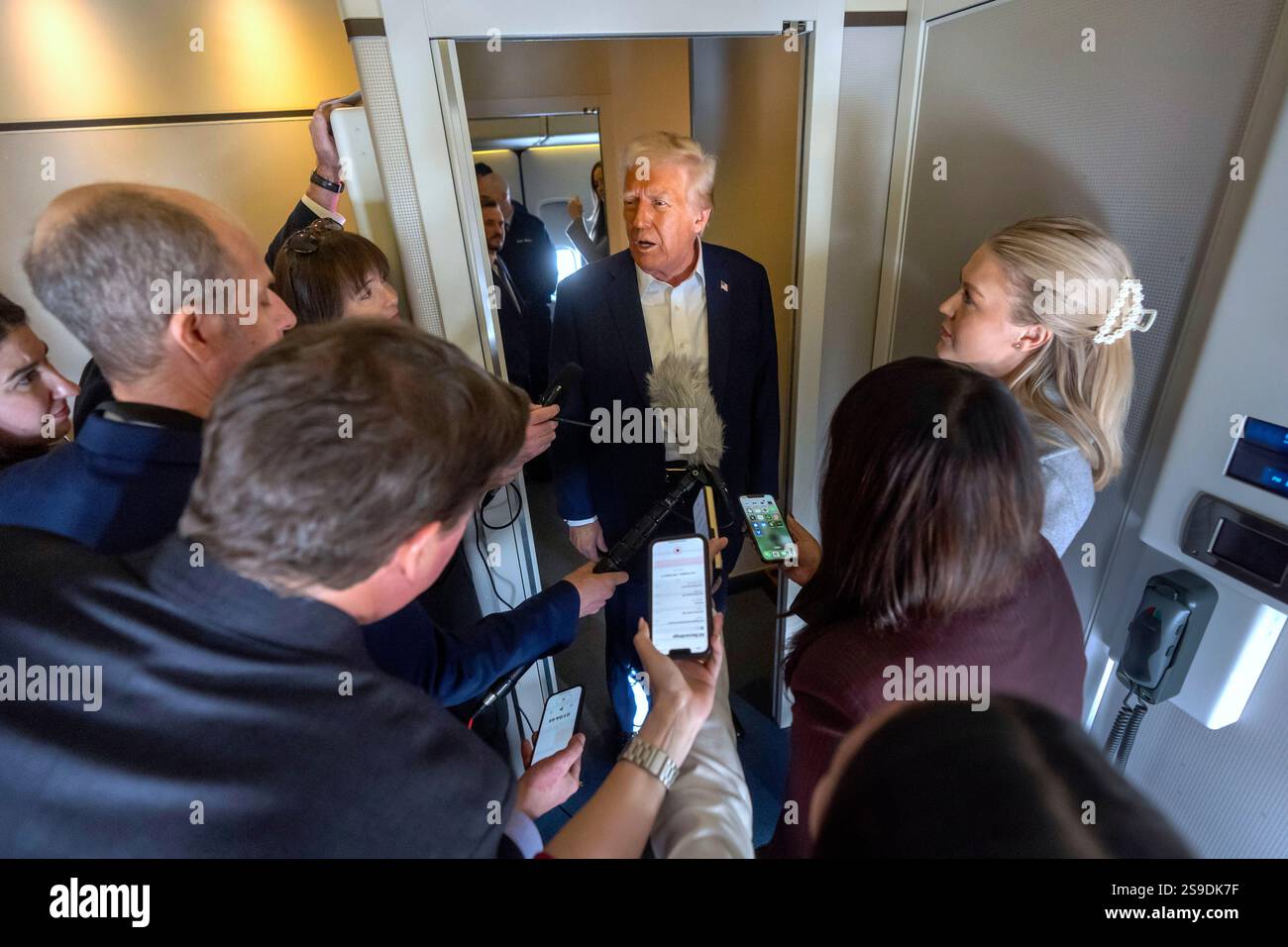 President Donald Trump speaks to reporters aboard Air Force One as he ...