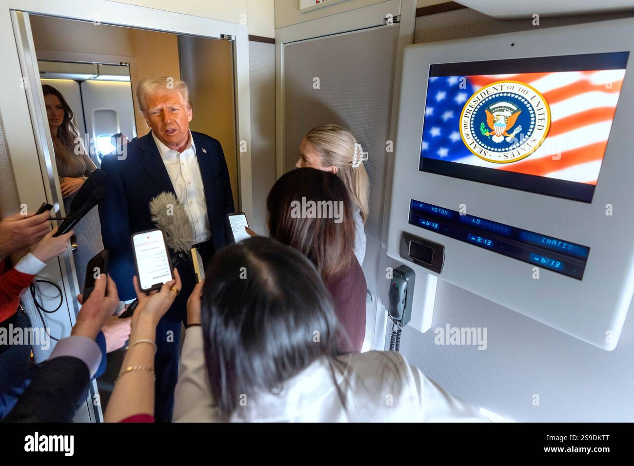 President Donald Trump speaks to reporters aboard Air Force One as he ...