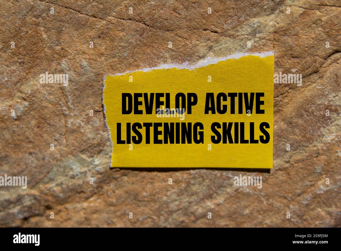 Develop active listening skills message written on ripped torn yellow ...