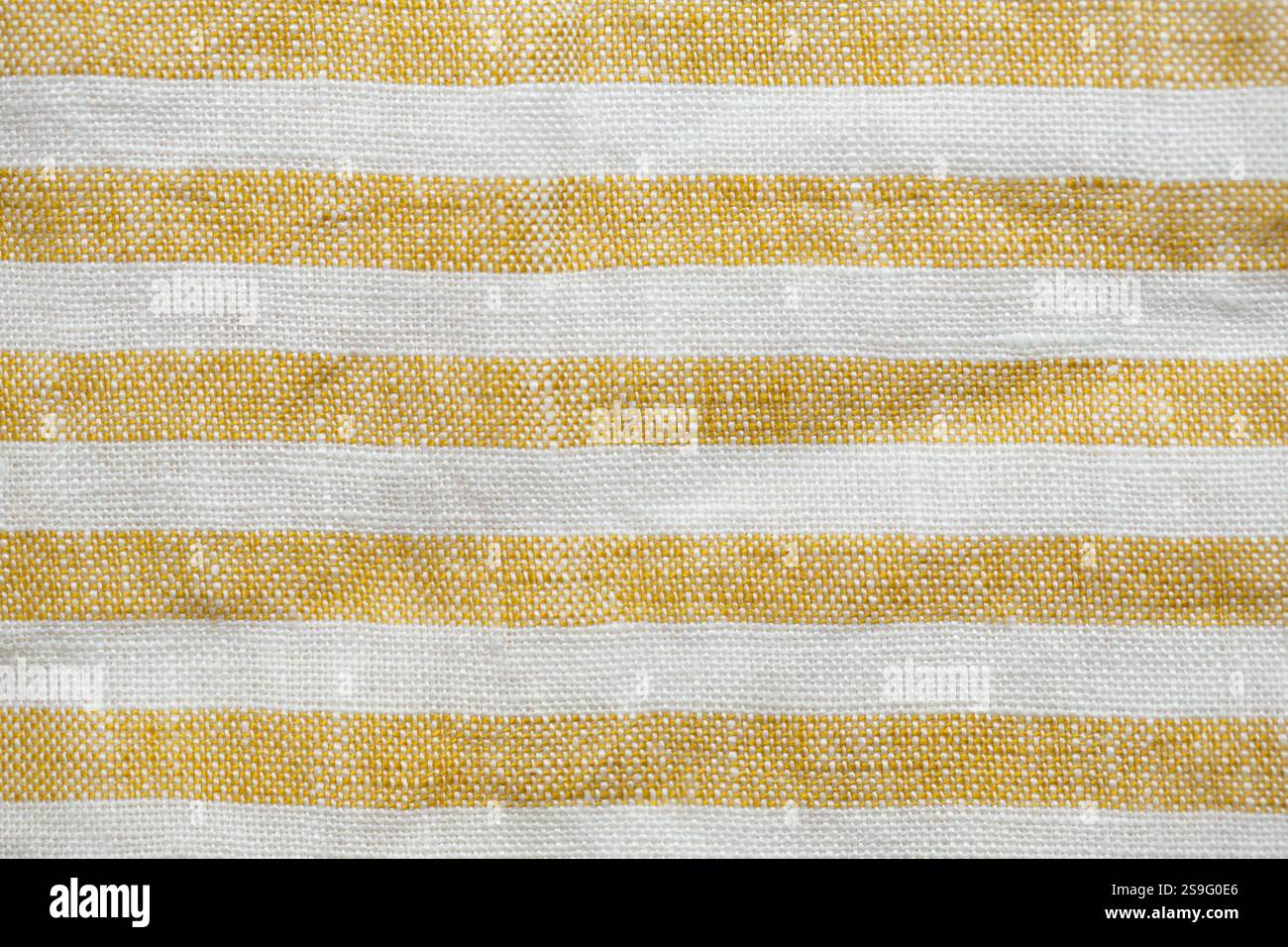 Yellow and white striped fabric with a rustic, woven texture. A seamless, natural pattern ideal for backgrounds, textiles, or decorative designs Stock Photo