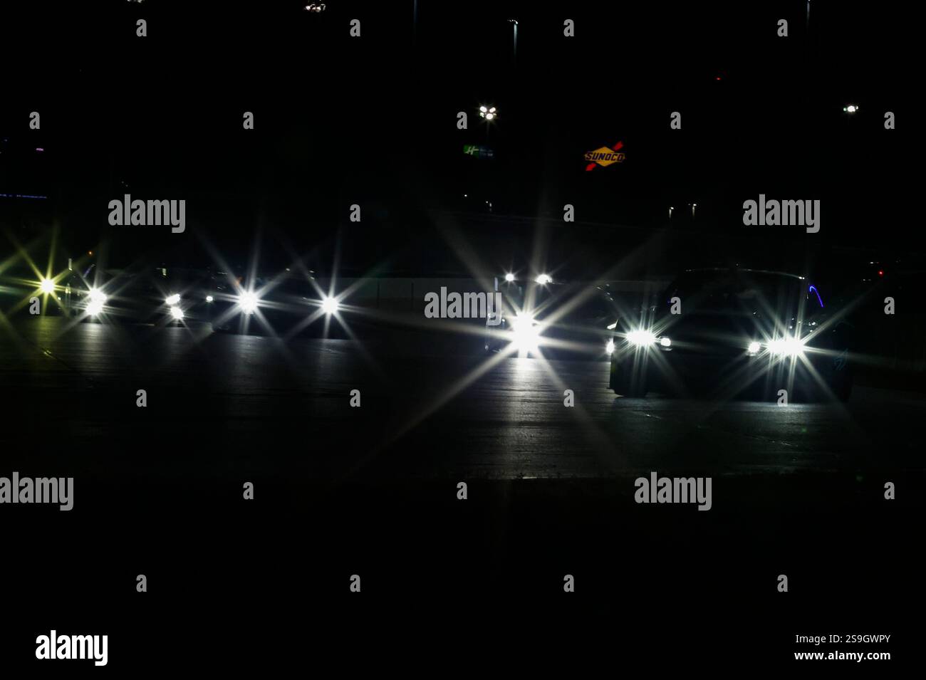 DAYTONA BEACH, FL - JANUARY 25: Cars race in the night during the Rolex ...