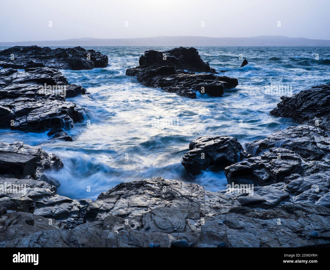 GODREVY ROCKS AND ROUGH SEA WAVES BREAKING OVER ROCKS Stock Photo - Alamy