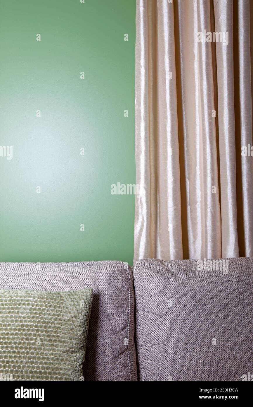 Sofa with pillows and a green wall in the background Stock Photo