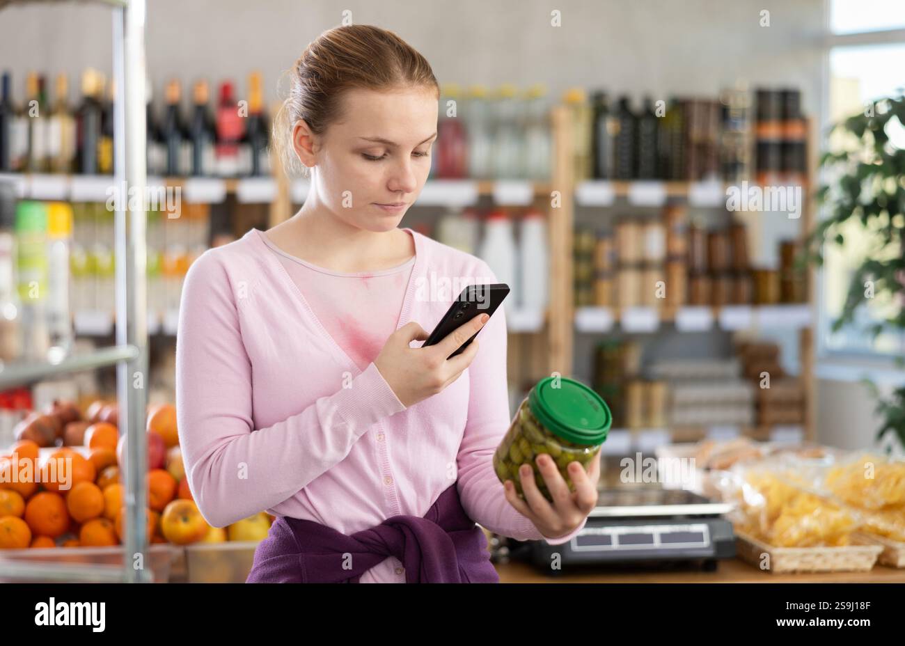 Young girl scanning qr code for olives Stock Photo - Alamy