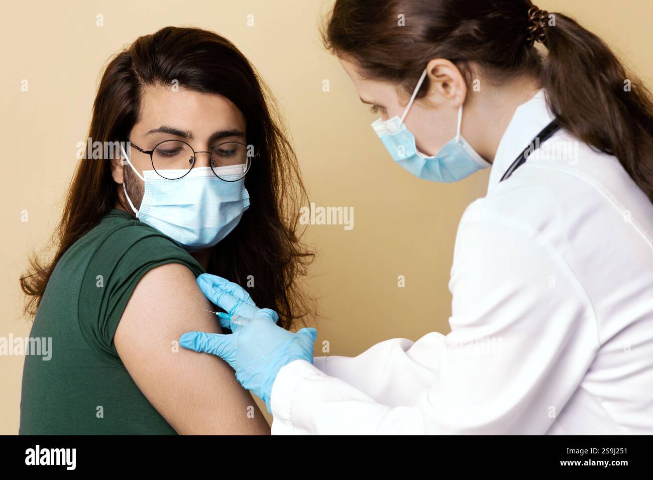 Woman doctor making intramuscular injection for arab guy at clinic ...