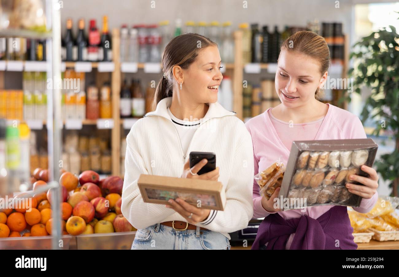 Young women scanning qr code for sweets Stock Photo - Alamy
