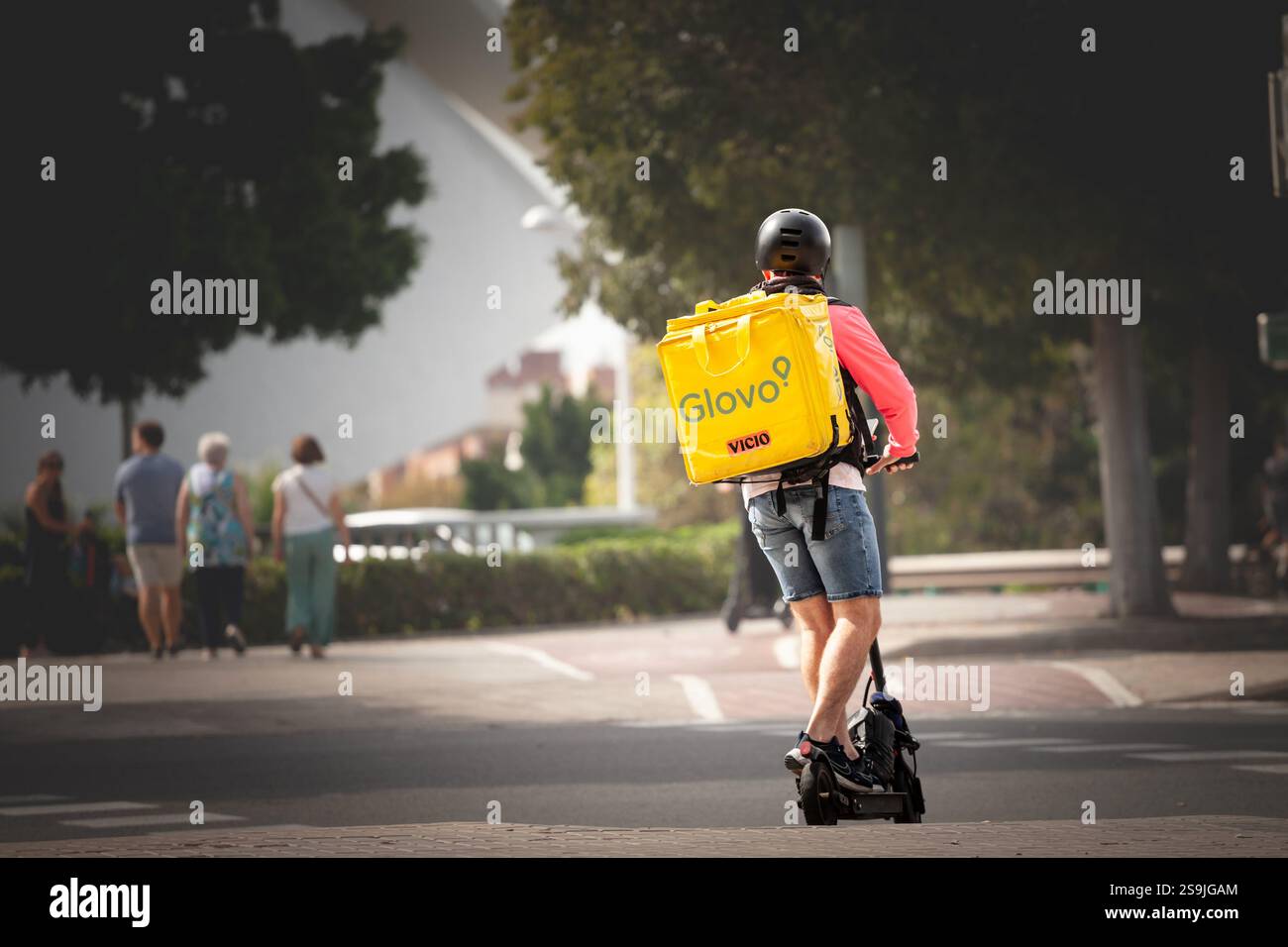 VALENCIA, SPAIN - OCTOBER 12, 2024: A Glovo delivery rider navigates ...