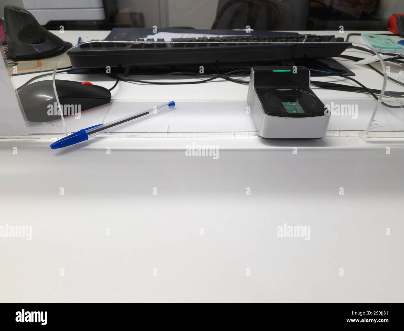 Public service conter with fingerprint scanner, pen and other office objects on a white desk. - Smartphone Captured Stock Image