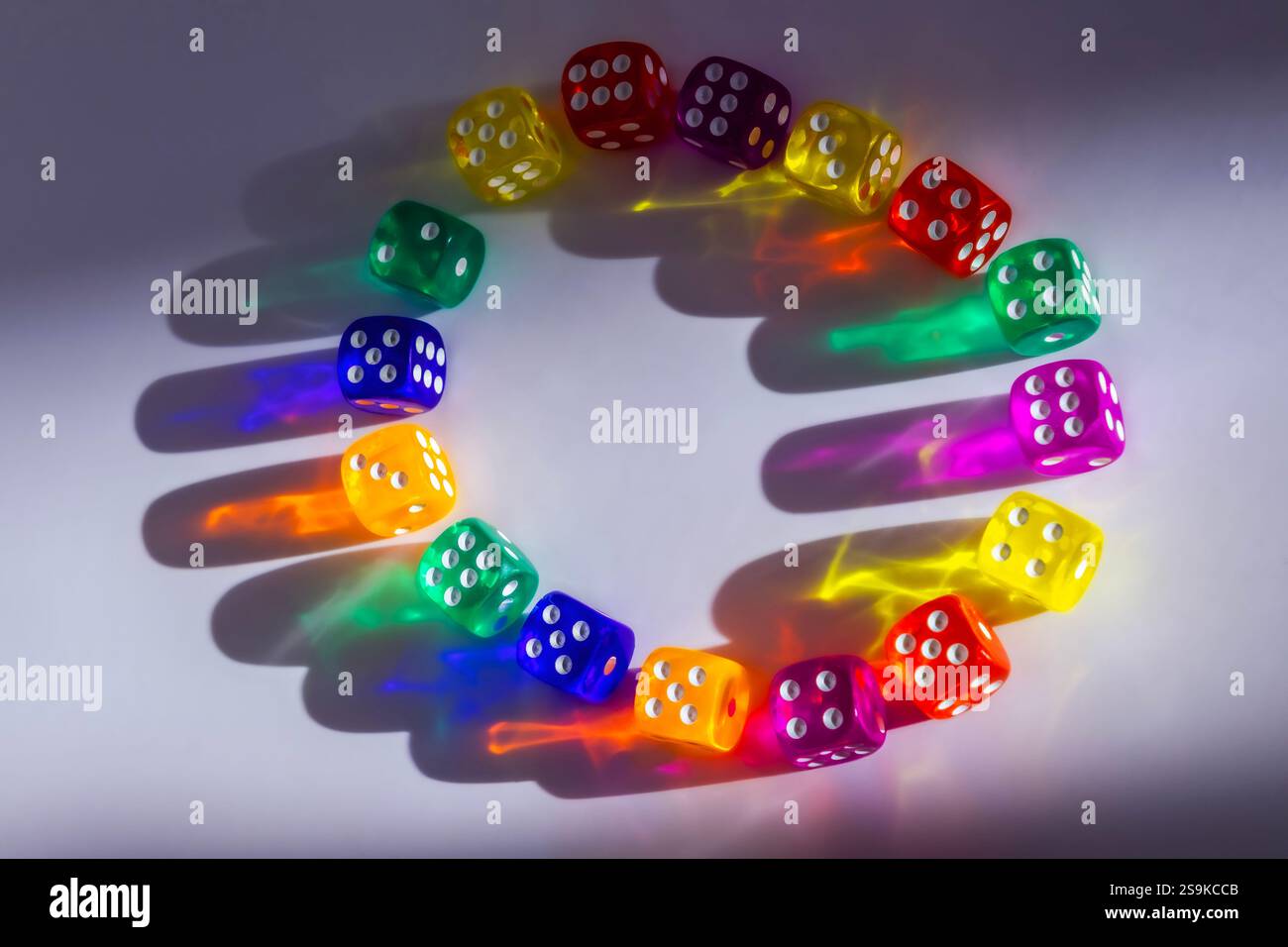 transparent colored dice on paper with shadows Stock Photo