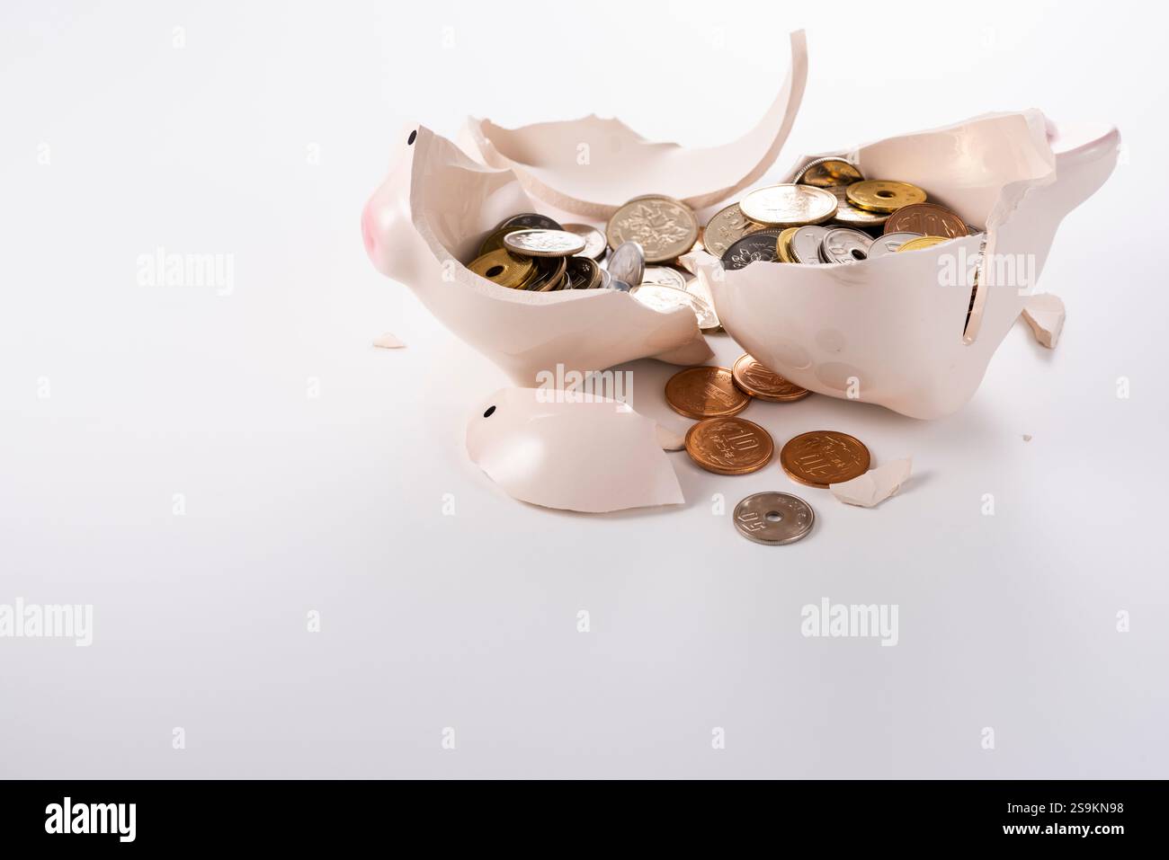 Broken piggy bank and coins Stock Photo