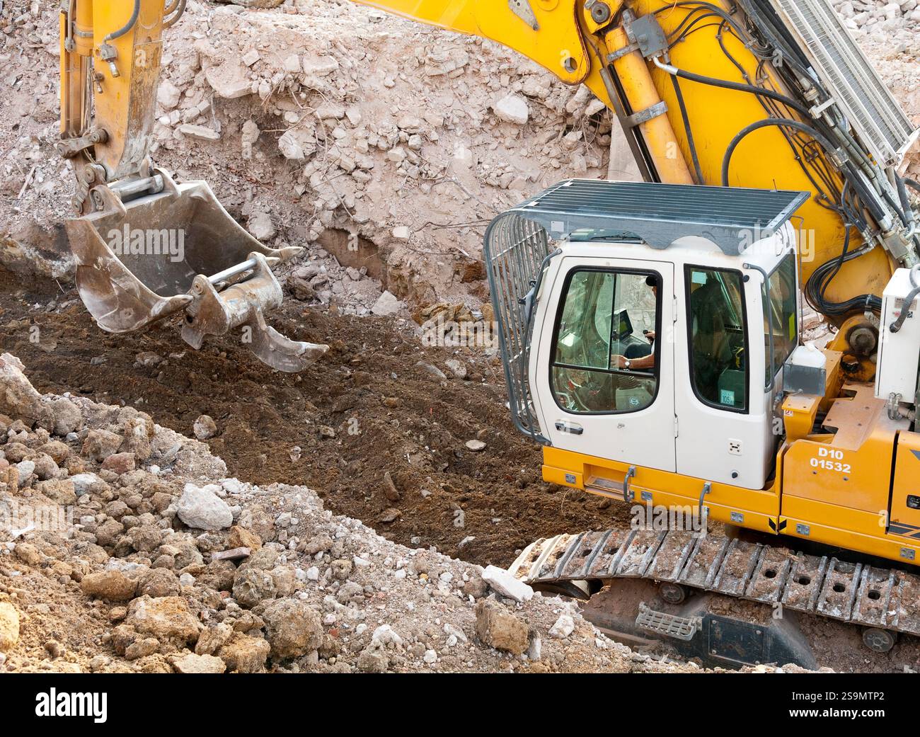 An excavator transports a ripper tooth with its bucket Stock Photo - Alamy