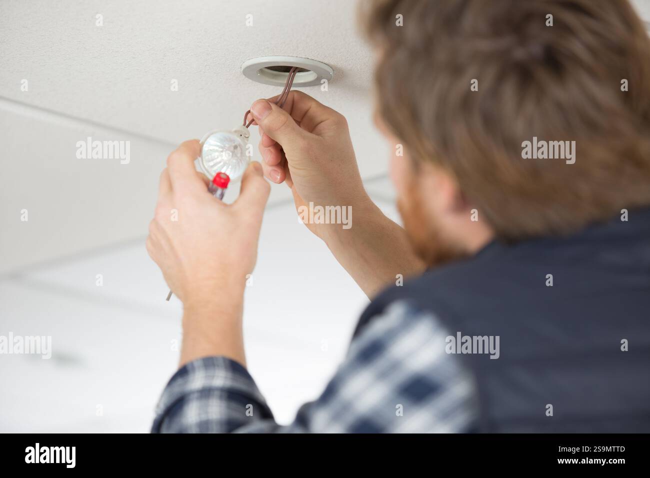 electrician installing spotlight bulb Stock Photo - Alamy