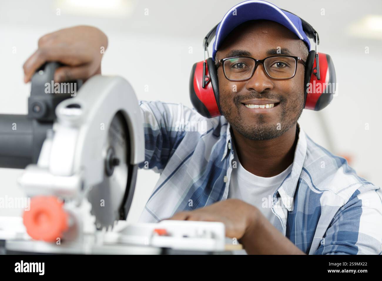 apprentice using circular saw in carpentry workshop Stock Photo
