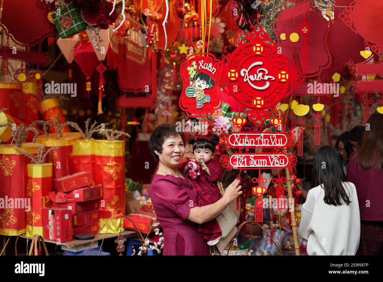 A woman holds her granddaughter as they visit the Lunar New Year "Tet