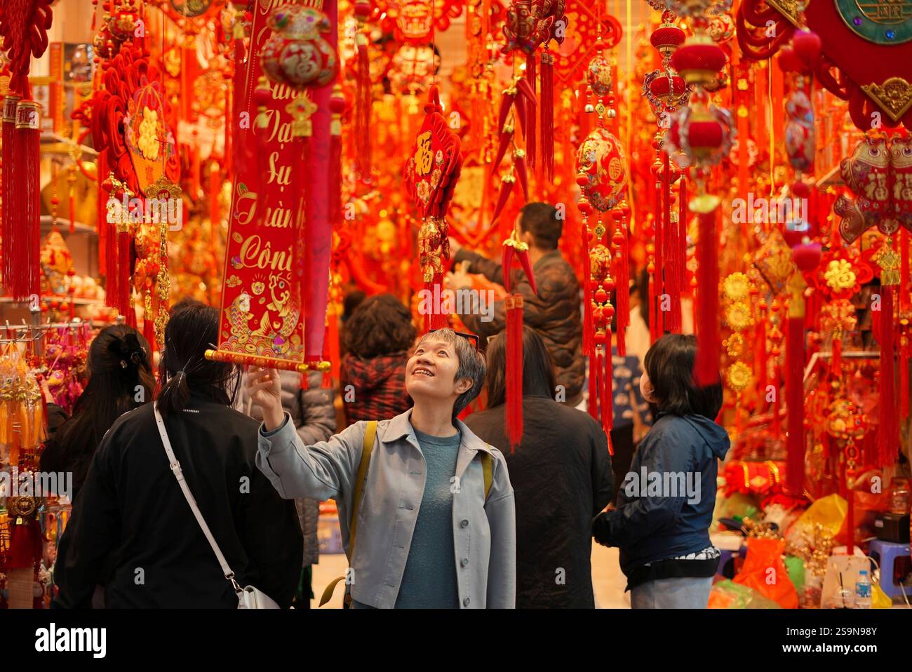 A woman looks at a decorative scroll at the Lunar New Year "Tet" market