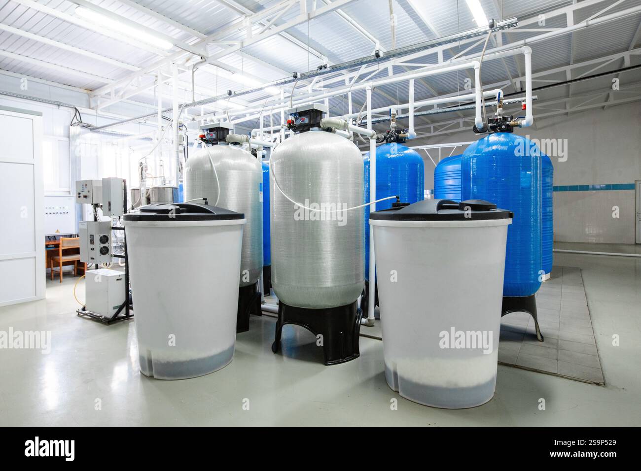 Industrial facility with large blue tanks and storage containers in a ...