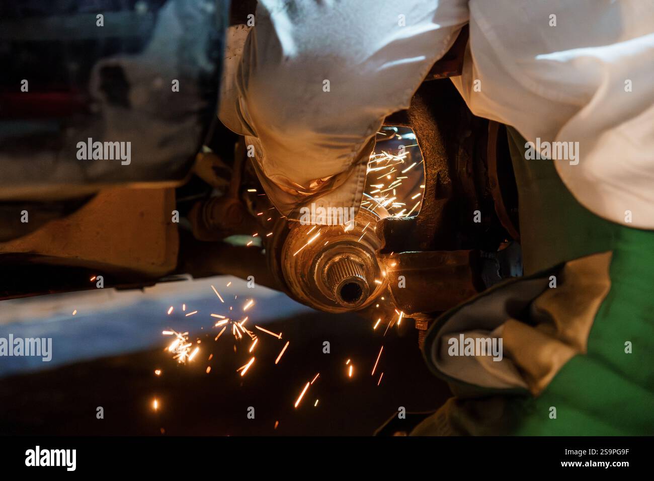 Sparks Fly as a Skilled Mechanic Performs Precision Metal Grinding Underneath a Vehicle. Stock Photo