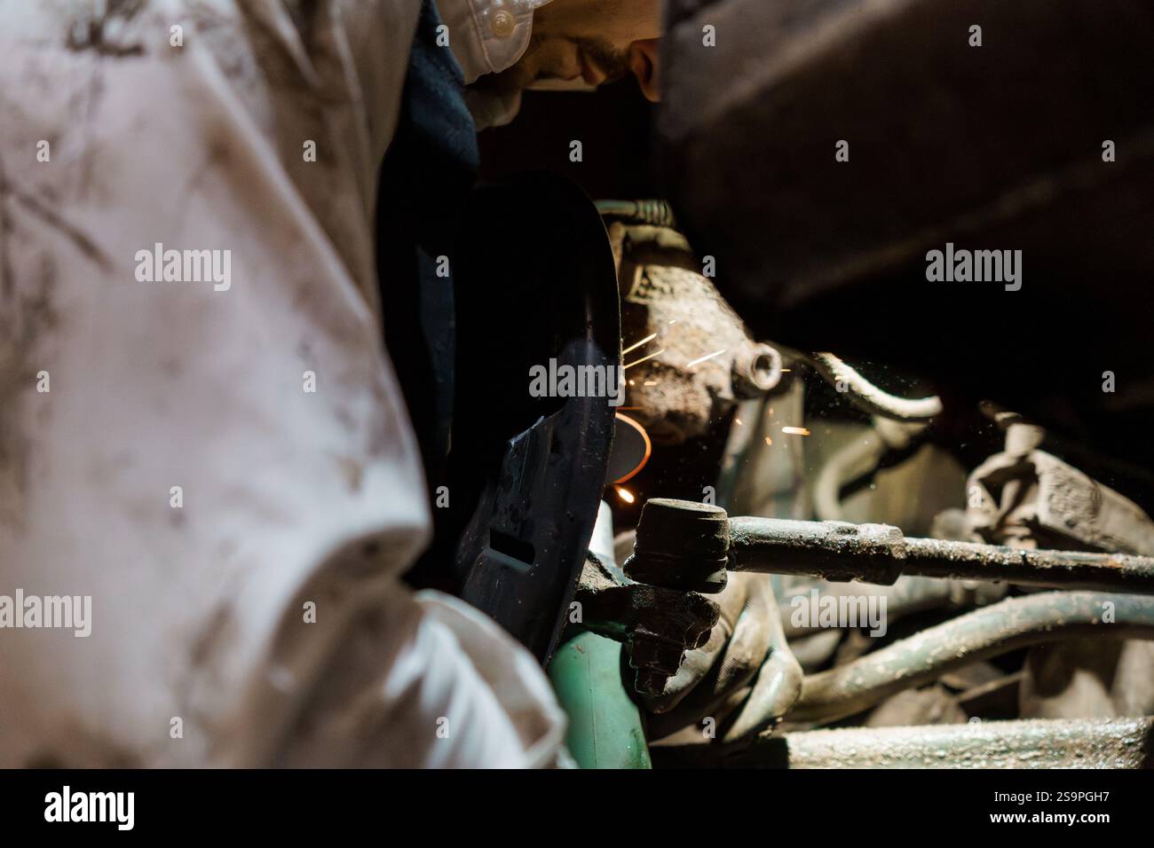 Sparks Fly as a Mechanic Performs Precision Welding on Automotive Components. Stock Photo
