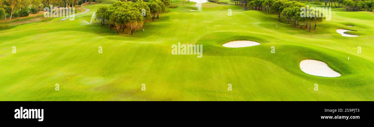 A panoramic view of a golf course with sand traps and vibrant greenery ...
