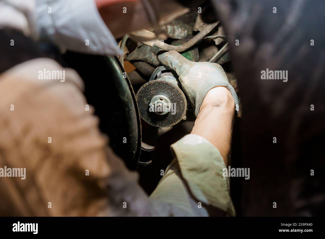Mechanic Working on a Car Engine with Precision in a Dimly Lit Garage ...