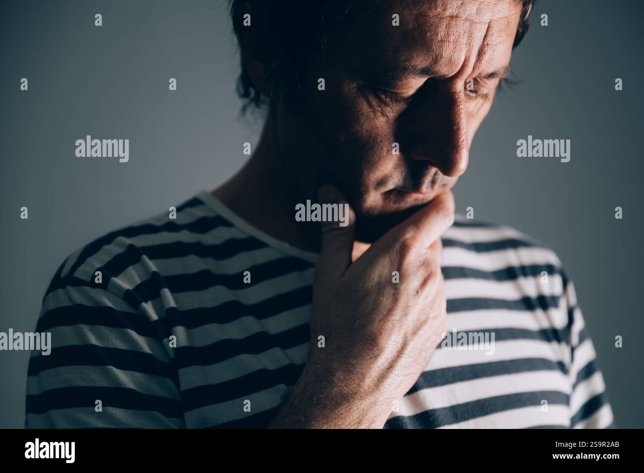 Low key portrait of sad distraught caucasian male in regret, selective ...