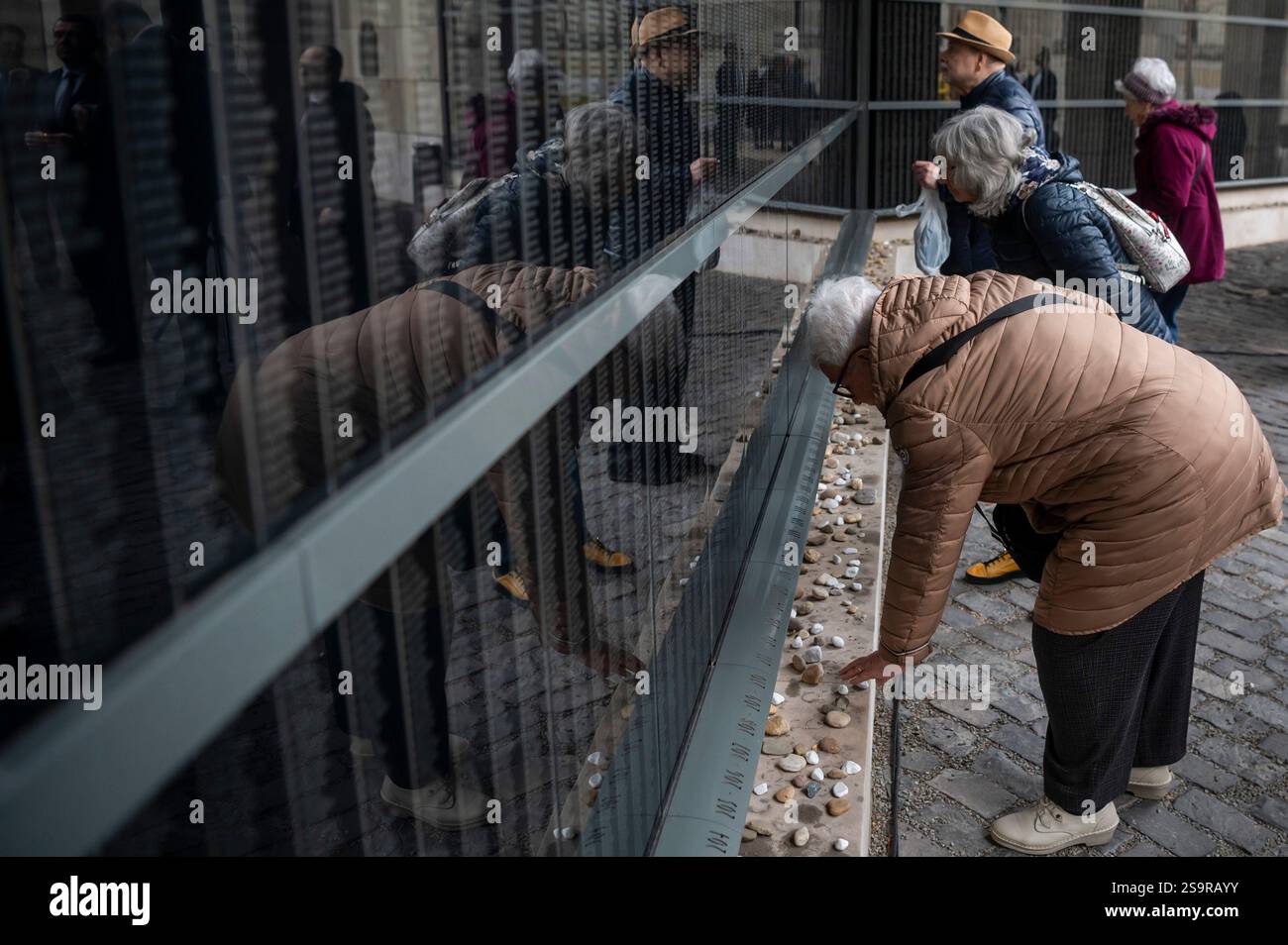 People visit the Wall of Remembrance, listing the victims' names
