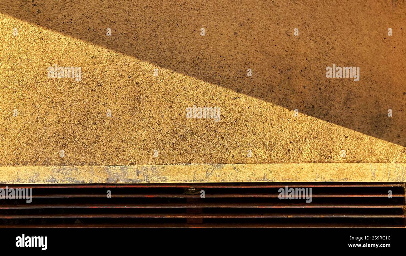 Geometric patterns and textures formed by a wall surface and shadows, creating an artistic composition - Smartphone Captured Stock Image