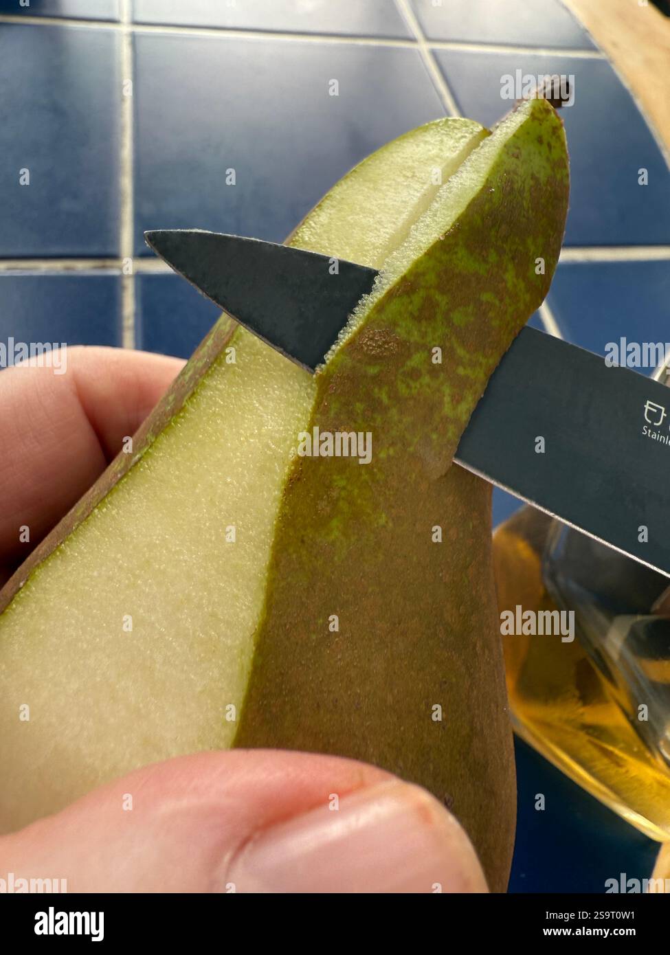 Peeling a conference pear with a knife - Smartphone Captured Stock Image
